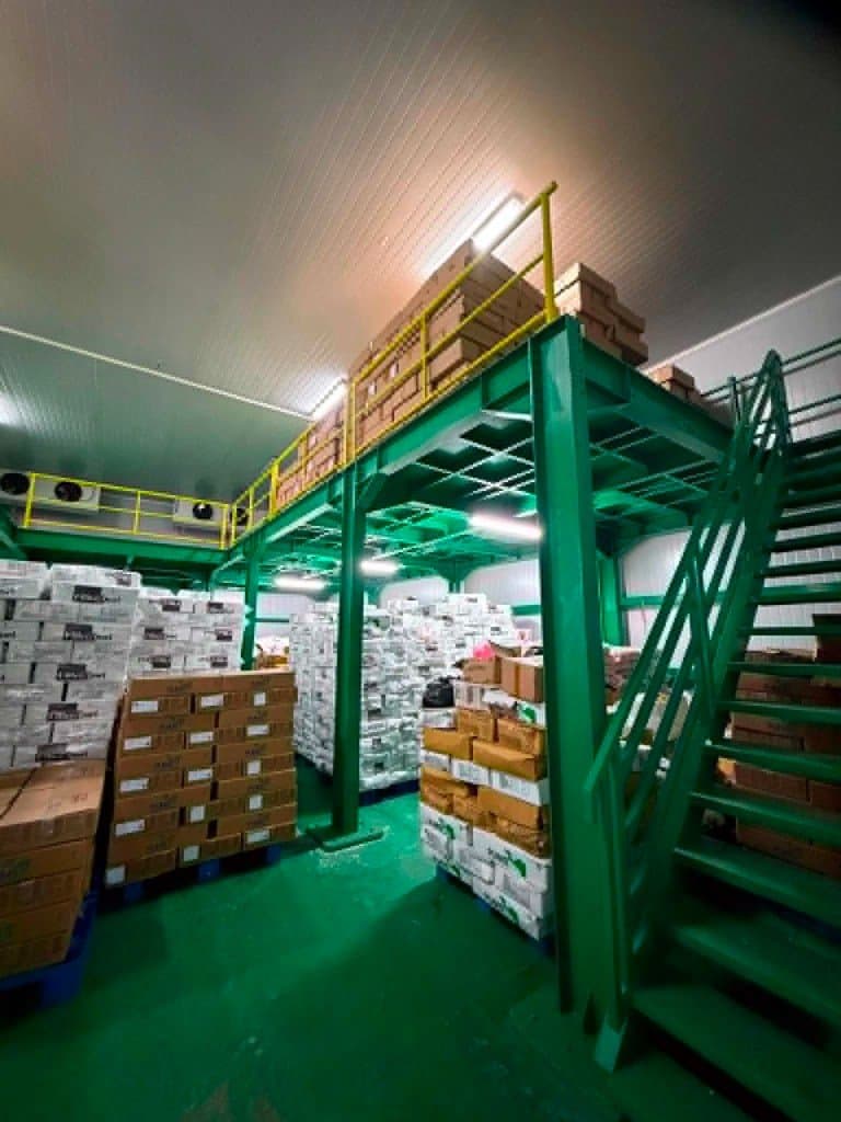 Cold storage facility with mezzanine stairs and palletized goods